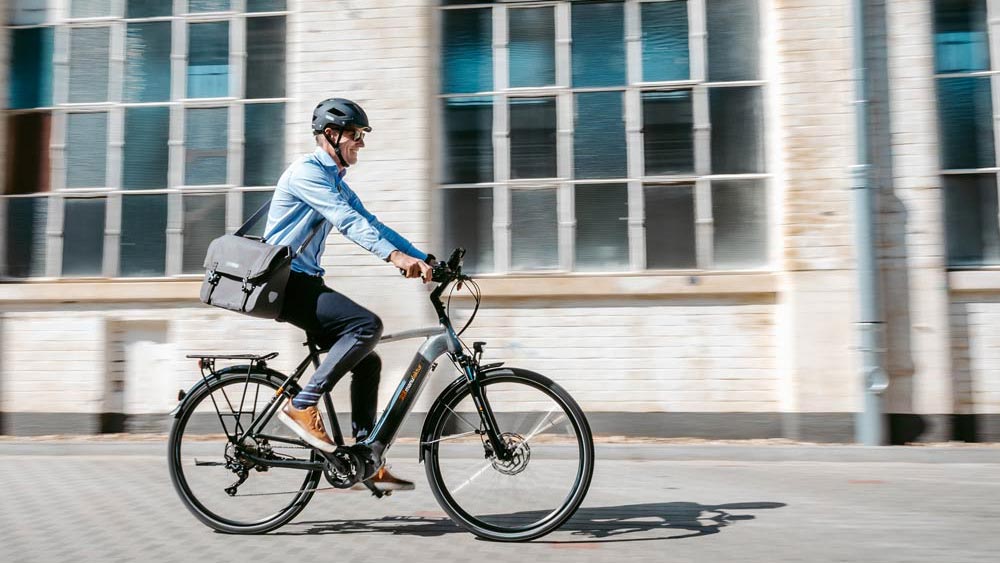 Arbeitnehmer auf einem Leasingfahrrad auf dem Weg ins Büro
